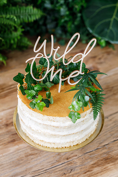 “Wild One” wood cake topper inserted in first birthday cake